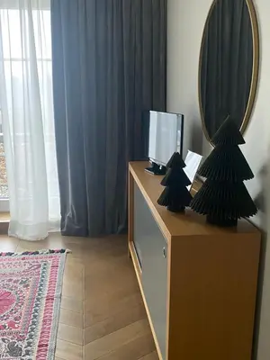 a room with a mirror and a dresser with a mirror at Kraków Green Hill Luxury Apartment in Balice