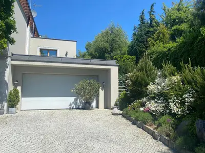 a garage with a white garage door on a driveway at Kraków Green Hill Luxury Apartment in Balice