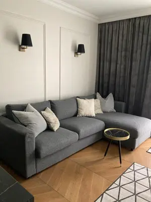 a living room with a gray couch and a table at Kraków Green Hill Luxury Apartment in Balice
