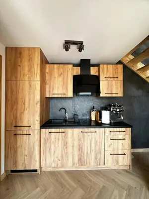 a kitchen with wooden cabinets and a sink at Domki Jasicówka pod Łysą Górą in Limanowa
