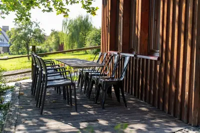 a row of chairs and tables on a porch at Domki Jasicówka pod Łysą Górą in Limanowa