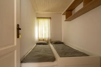 a small bed in a small room with a window at Domki Jasicówka pod Łysą Górą in Limanowa