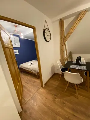 a room with a bed and a table and a mirror at Lu Residence - Unique Apartments in Oświęcim