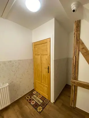 a room with a wooden door and a rug at Lu Residence - Unique Apartments in Oświęcim