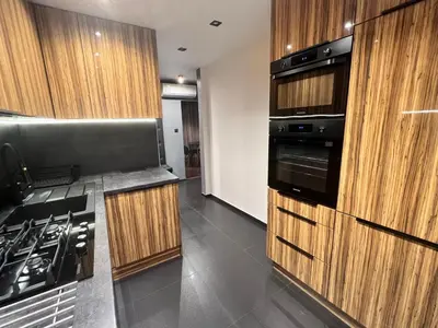 a kitchen with wooden cabinets and a stove at V&O Apartament Old Town Kazimierz in Kraków