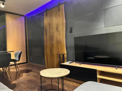 a room with a large television and a table and chairs at V&O Apartament Old Town Kazimierz in Kraków