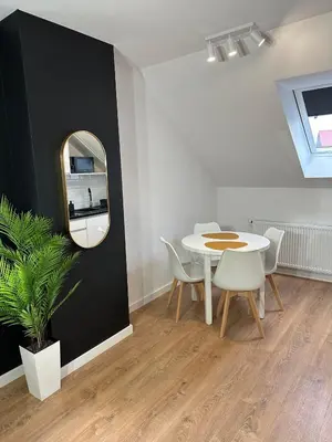 a yellow couch in a living room with a black wall at Apartamenty Avia - Energylandia Zator in Spytkowice