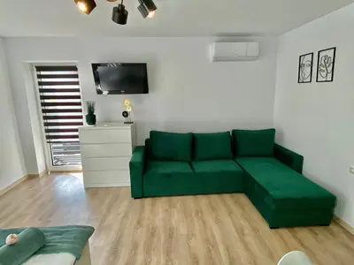 a living room with a green couch and a table at Apartamenty Avia - Energylandia Zator in Spytkowice
