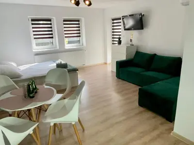 a living room with a blue wall and a blue couch at Apartamenty Avia - Energylandia Zator in Spytkowice
