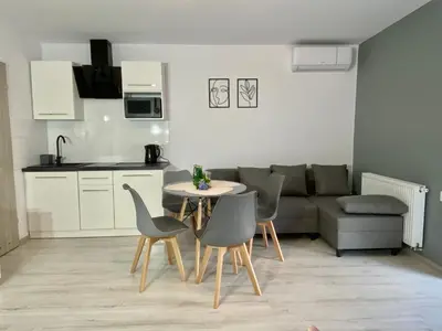 a living room with a table and a yellow couch at Apartamenty Avia - Energylandia Zator in Spytkowice