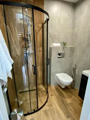 a shower with a glass enclosure in a bathroom at Apartamenty Avia - Energylandia Zator in Spytkowice