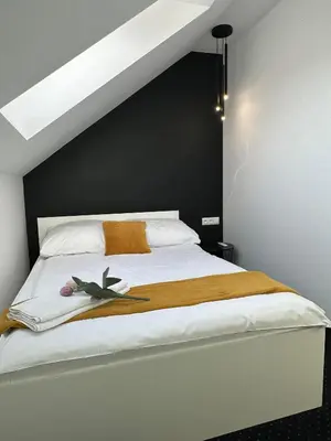 a bedroom with a bed with a blue wall at Apartamenty Avia - Energylandia Zator in Spytkowice