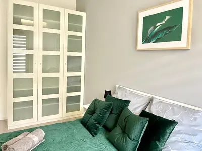 a living room with a couch with green pillows at Modern Green Apartment in Kraków