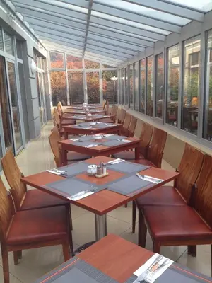 a row of tables and chairs in a room with windows at H6 MAJOR ApartHotel Travel & Business, FREE PARKING in Kraków