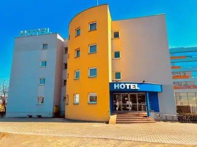 a hotel with a yellow building next to a building at H6 MAJOR ApartHotel Travel & Business, FREE PARKING in Kraków