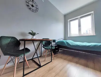 a room with a desk and a bed and a table and chairs at Krakowska Awangarda - Close to the Old Town in Kraków