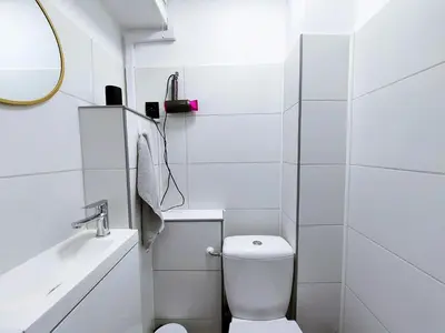 a white bathroom with a toilet and a sink at Krakowska Awangarda - Close to the Old Town in Kraków