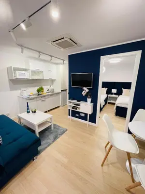a living room with a couch and a blue wall at Beds Friends Apartments in Zator