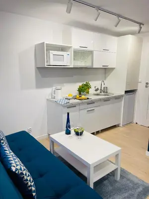 a living room with a blue couch and a table at Beds Friends Apartments in Zator