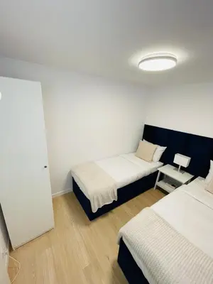 a room with two beds and a table in it at Beds Friends Apartments in Zator