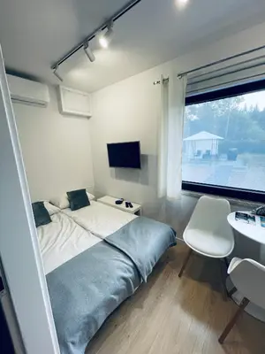 a bedroom with a bed and a desk and a window at Beds Friends Apartments in Zator