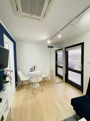 a living room with a white table and chairs at Beds Friends Apartments in Zator