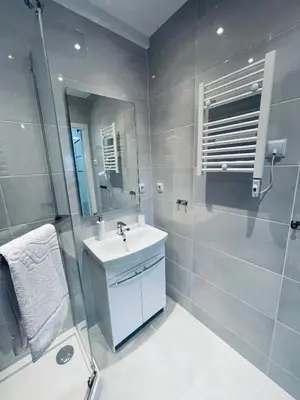 a white bathroom with a sink and a shower at Beds Friends Apartments in Zator