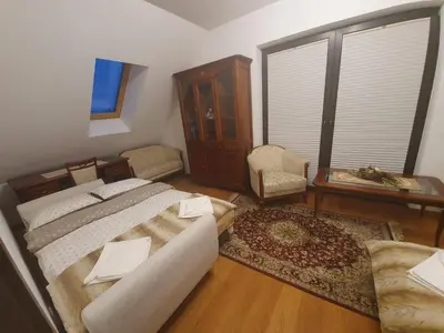 a bedroom with a bed and a chair and a window at Willa pod Babią Górą in Zubrzyca Górna