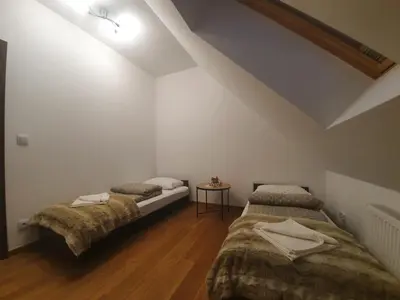a bedroom with two beds and a table at Willa pod Babią Górą in Zubrzyca Górna