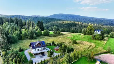 an aerial view of a large house on a green field at Willa pod Babią Górą in Zubrzyca Górna