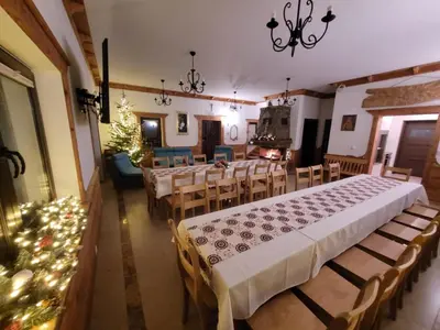 a dining room with tables and chairs with christmas lights at Willa pod Babią Górą in Zubrzyca Górna