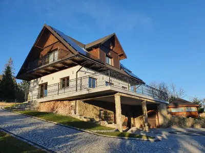 a large wooden house with a gambrel roof at Willa pod Babią Górą in Zubrzyca Górna