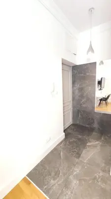 a living room with a marble floor and white walls at Skawińska 10 by Homeprime in Kraków