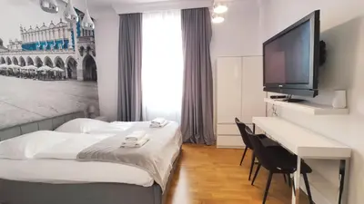 a hotel room with a bed and a desk with a television at Skawińska 10 by Homeprime in Kraków