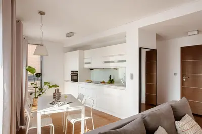 a white living room with a table and a couch at Spacious apartment close to Main Station / Galeria Krakowska in Kraków