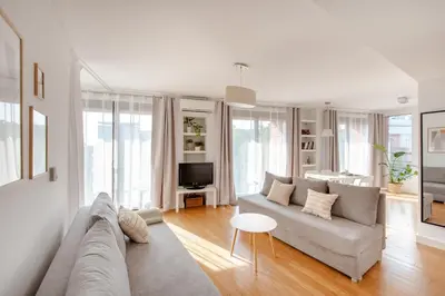 a white living room with a couch and a tv at Spacious apartment close to Main Station / Galeria Krakowska in Kraków