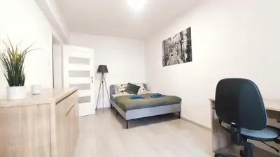 a bedroom with a bed and a desk and a chair at Dąbska 18D by Homeprime in Kraków