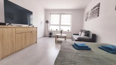 a bedroom with a tv and a bed and a couch at Dąbska 18D by Homeprime in Kraków