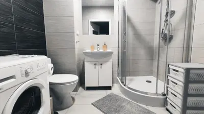 a bathroom with a toilet a sink and a washing machine at Dąbska 18D by Homeprime in Kraków