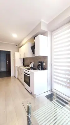 a kitchen with white cabinets and a stove at Dąbska 18D by Homeprime in Kraków