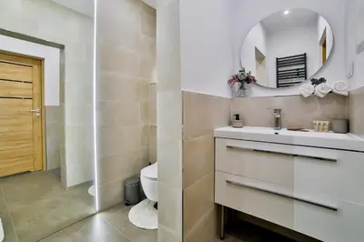 a bathroom with a sink and a toilet and a mirror at Studio ArtDeco in Rabka