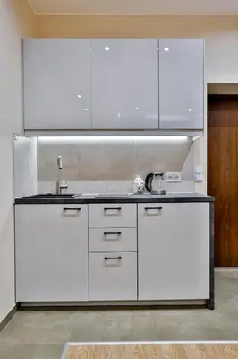 a kitchen with white cabinets and a sink at Studio ArtDeco in Rabka