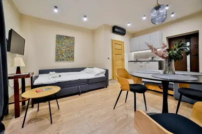 a living room with a bed and a table and chairs at Studio ArtDeco in Rabka