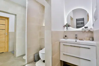 a bathroom with a toilet and a sink and a mirror at Studio ArtDeco in Rabka