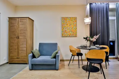 a living room with a blue chair and a table at Studio ArtDeco in Rabka