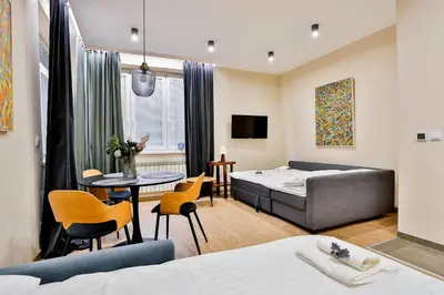 a hotel room with a bed and a table and chairs at Studio ArtDeco in Rabka