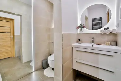 a bathroom with a sink and a toilet and a mirror at Studio ArtDeco in Rabka