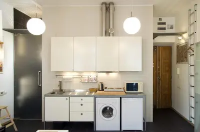a kitchen with white cabinets and a washing machine at New Sweet One in Kraków