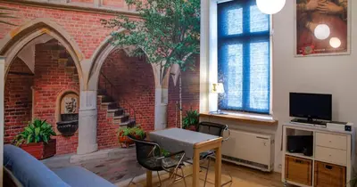 a living room with a brick wall and a table at New Sweet One in Kraków