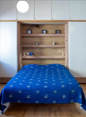 a bedroom with a blue bed with a wooden headboard at New Sweet One in Kraków